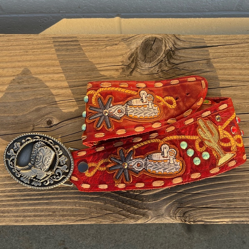 Red leather western belt with embroidery, patches, and gems